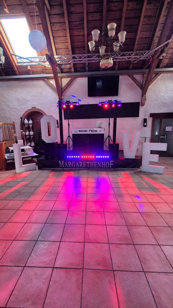 DJ-Setup von Maik Nox DJ-Setup von Maik Nox mit Mischpult, Tisch und Ton- & Lichttechnik mit warmen Akzenten für den Hochzeitsabend